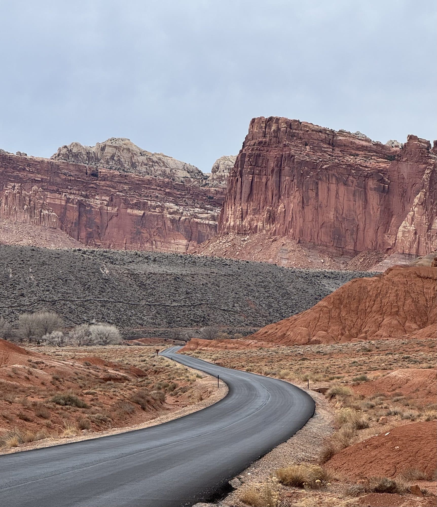 A road winding on between red cliffs