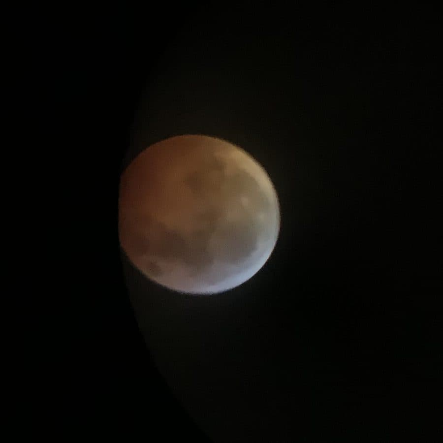 The moon in total eclipse, glowing copper-red