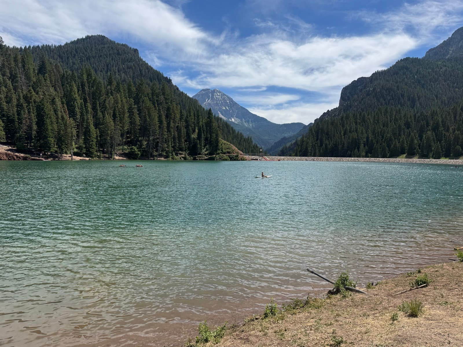 Alpine lake at midday, a solitary paddleboarder mid-water