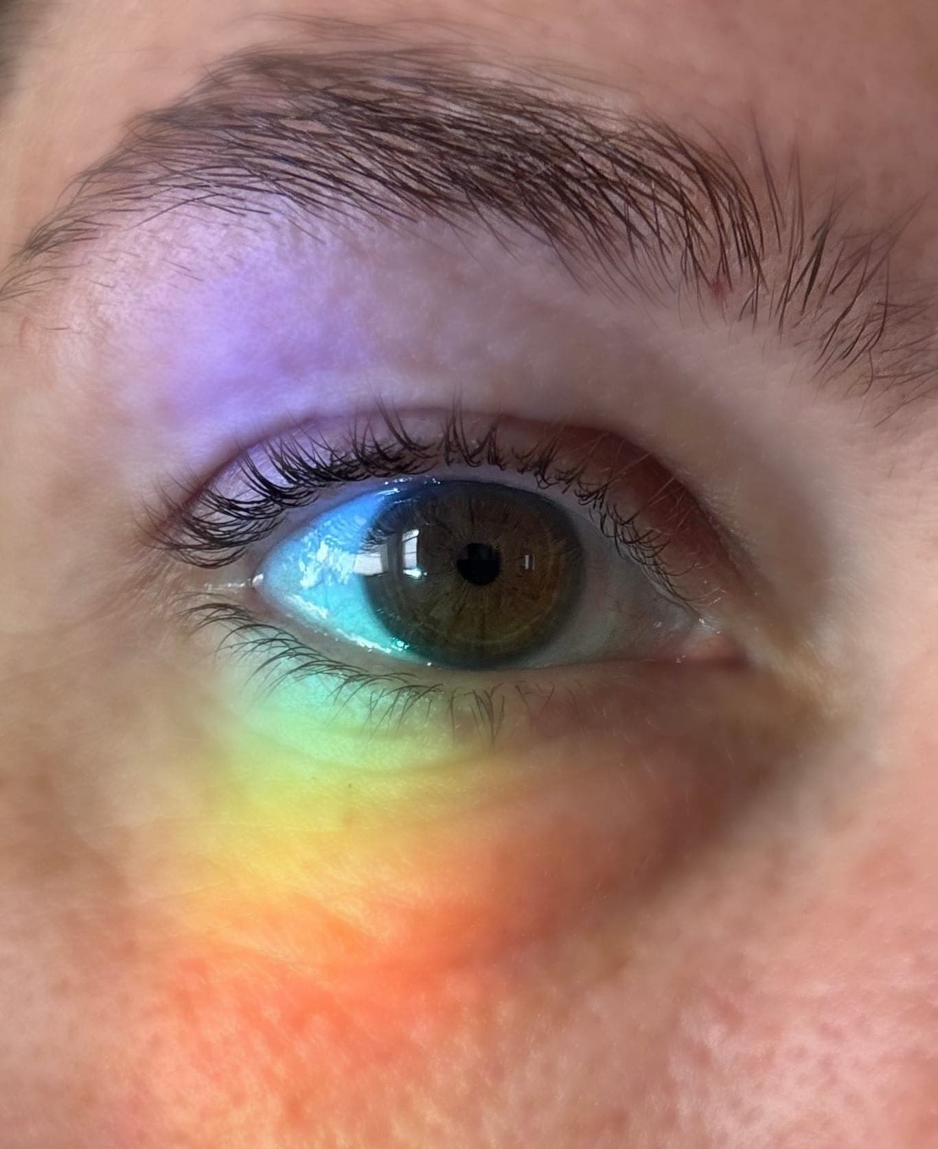 A close view of Rachel's eye with a band of rainbow light across it