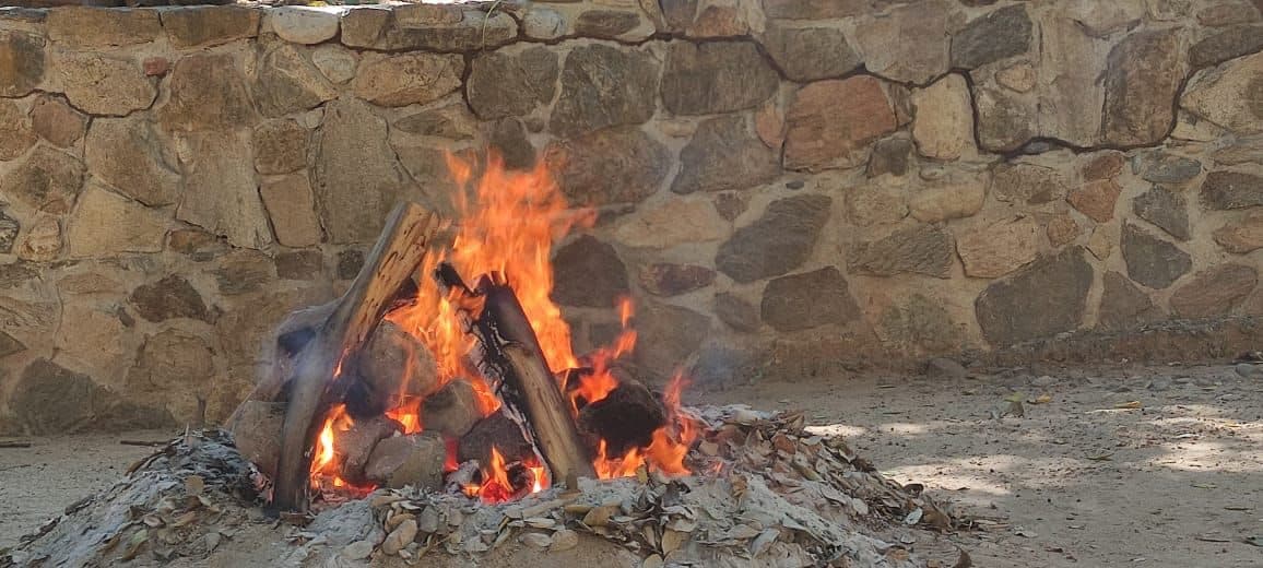 A fire burning bright against an old stone wall