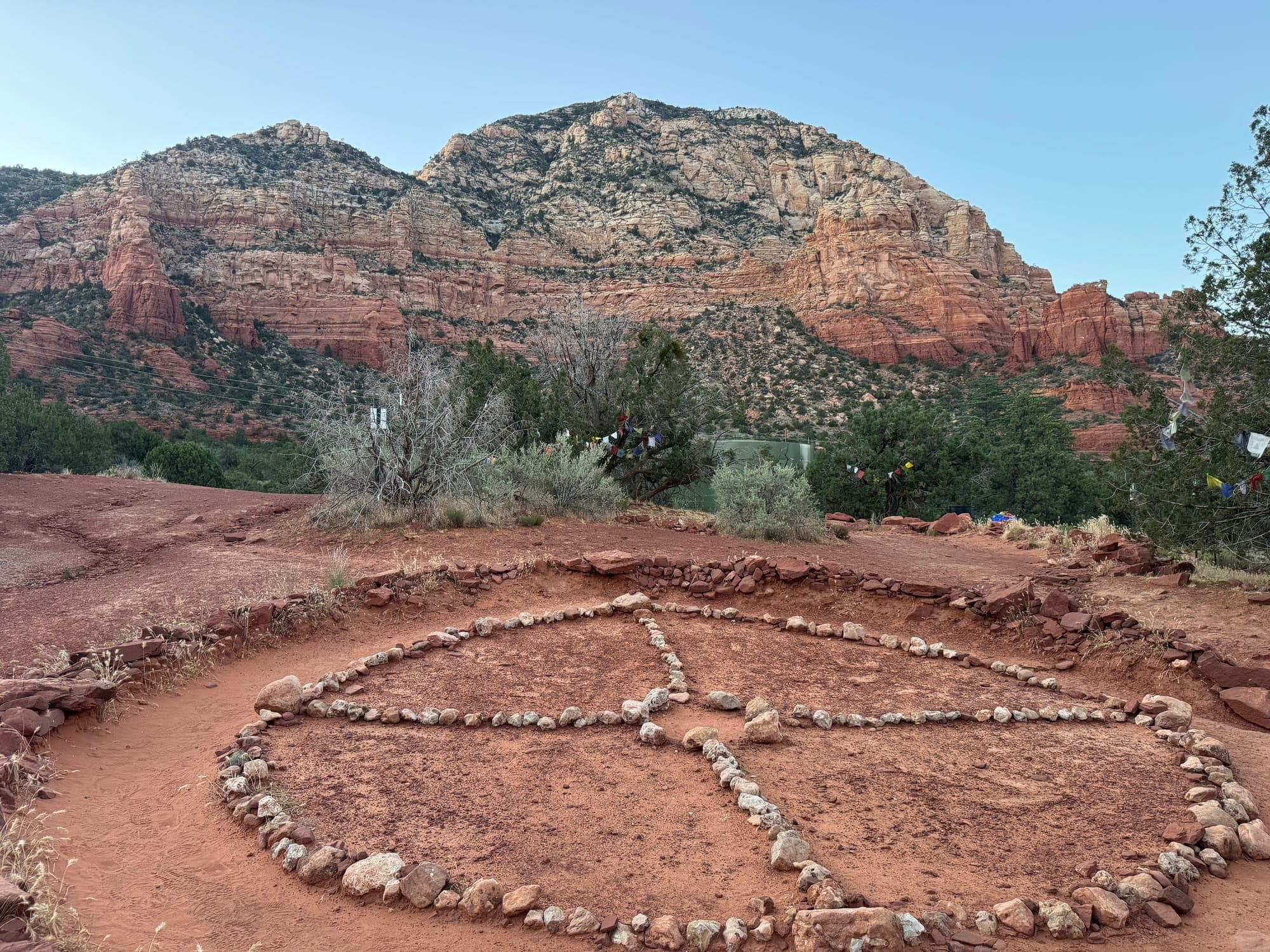 A circle of stones laid in the red earth below the cliffs